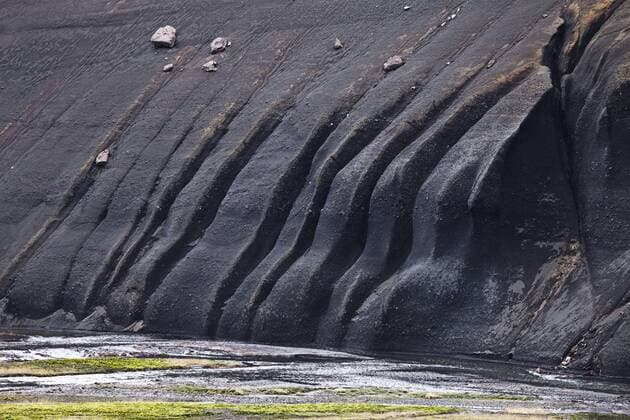  Auf der schwarzen Lava bilden sich Risse an einem Hang im Fjallabak Naturschutzgebiet, Hochland von Island, Europa iblmpw02202559