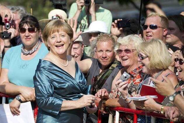 Bundeskanzlerin Angela MERKEL schreibt Autogramme, ganze Figur, Ganzkoerper, Eröffnung der Bayreuther Richard Wagner Festspiele Roter Teppich am 25.07.2012. Grüner Hügel, Festspielhaus. Â