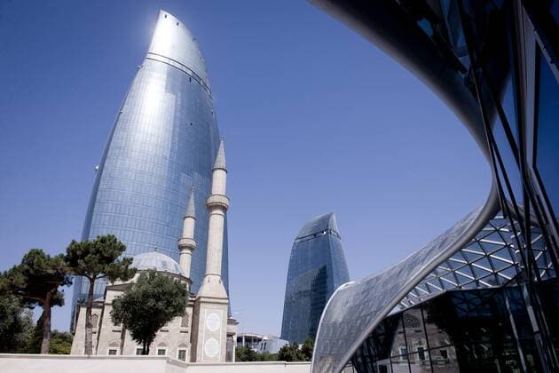 Baku, Azerbaijan, 26 July 2012 View of the Flames towers. Baku is the capital and largest city of Azerbaijan, as well as the largest city on the Caspian Sea and of the Caucasus region. It is located on the southern shore of the Absheron Peninsula, which projects into the Caspian Sea. The city consists of two principal parts: the downtown and the old Inner City (21.5 ha). Baku s urban population at the beginning of 2009 was estimated at just over two million people. Officially, about 25 percent of all inhabitants of the country live in the metropolitan city area of Baku. Photo: Reporters Ezequiel Scagnetti 