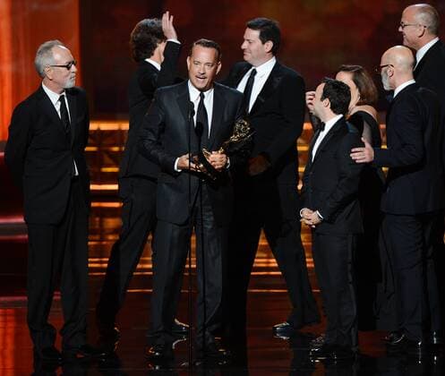 Producers Gary Goetzman, Jay Roach and Tom Hanks (L-R) accept Outstanding Miniseries or TV Movie Emmy for Game Change onstage during the 64th annual Primetime Emmy Awards at the Nokia Theatre in Los Angeles on September 23, 2012. At rear are the books authors, John Heilemann (L) and Mark Halperin.  LAP20120923930
