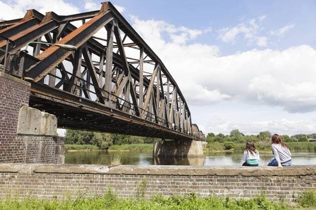 Eisenbahnbrücke über den Grenzfluss Oder, deutsch-polnische Grenze von Küstrin nach Kostrzyn, zwei Mädchen sitzen auf einer Mauer mit Blick nach Polen, Brandenburg, Deutschland, Europa iblren02357088