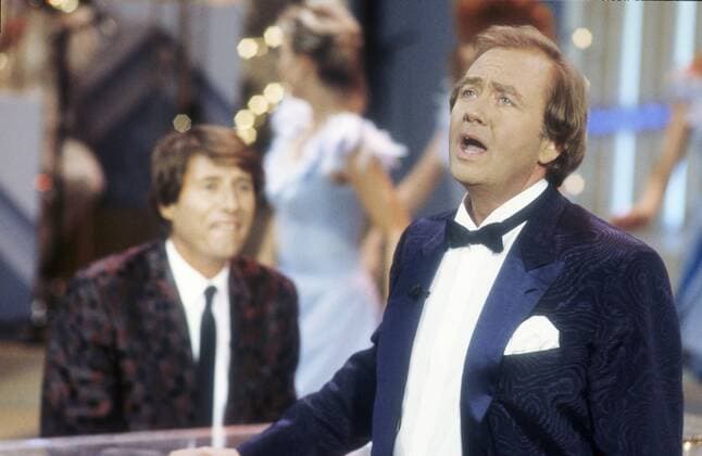 Rene Kollo mit Udo Jürgens (hinten) 08 86 rag René Kollo (vorne) und Udo Jürgens im August 1986 in Musik war meine erste Liebe TV Fernsehen Musiksendung Musik Deutschland deutsch deutscher Mann Musik Gesang Kammersänger Tenor Klassik klassische Schlager Schlagersänger Sänger Österreich Österreicher österreichischer Komponist Musiker Chanson german austrian musician composer writer singer quer halb Portrait stehend singend gestikulierend sitzend Flügel spielend Auftritt Bühne Kulisse