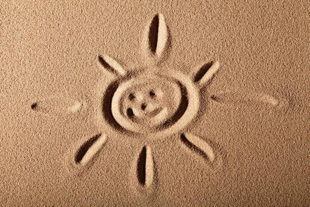  Sonne mit Gesicht in den Sand gemalt ibltsv02403243