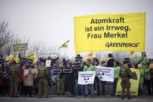 Mahnwache Atomkraft abschalten DEU, Deutschland, Germany, Berlin, 15.03.2011 Demonstranten mit Plakat Atomkraft ist ein Irrweg Frau Merkel von Greenpeace bei der Kundgebung und Mahnwache fuer den Atomausstieg unter dem Motto Atomkraft abschalten, Atomausstieg jetzt vor dem Bundeskanzleramt in Berlin. Die Kundgebung organisiert von Campact und anderen Antiatominitiativen fordert die Abschaltung aller Atomkraftwerke und erinnert an die Auswirkungen der Naturkatastrophe in Japan und das Desaster der japanischen Atomkraftwerke. Kundgebung gegen die Atompolitik der schwarz-gelben Koalition und der Bundesregierung. Atomkraft Nein Danke, Atomkraftgegner, Antiatombewegung, Anti-Atom-Demo, Antiatom, Anti-Atomkraft, Atomkraft, Atomkraftwerke, Anti-Atom, Anti-Atom-Bewegung, Atomenergie, Atompolitik, Anti, Atomenergie, Demonstration, demonstrieren, Demonstrant, Demonstranten, Atomkraftgegener, Kern