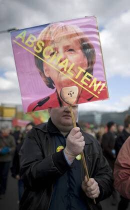 Demonstration fuer den Atomausstieg DEU, Deutschland, Germany, Berlin, 26.03.2011 Demonstrant mit Plakat Abschalten Merkel nicht bei der Demonstration mit ca 90.000 Menschen fuer den Atomausstieg unter dem Motto Fukushima mahnt alle AKWS Abschalten fuer einen sofortigen Ausstieg aus der Atomenergie in Berlin. Die bundesweiten Demonstrationen thematisieren die Auswirkungen der Naturkatastrophe in Japan und das Desaster der japanischen Atomkraftwerke. Kundgebung gegen die Atompolitik der schwarz-gelben Koalition und der Bundesregierung. Atomkraft Nein Danke, Atomkraftgegner, Antiatombewegung, Anti-Atom-Demo, Antiatom, Anti-Atomkraft, Atomkraft, Atomkraftwerke, Anti-Atom, Anti-Atom-Bewegung, Atomenergie, Atompolitik, Anti, Atomenergie, Demonstration, demonstrieren, Demonstrant, Demonstranten, Atomkraftgegener, Kernkraft, Kernkraftwerk, Kernkraftwerke, Kernenergie, Atomlobby, Atomdemo, Atomd