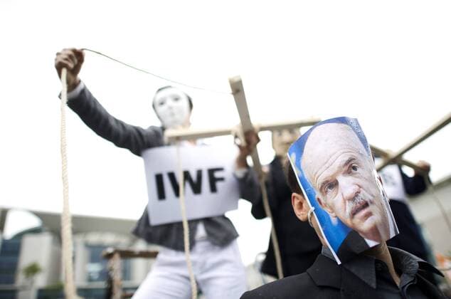 Protest Financial Crises, Berlin DEU, Deutschland, Germany, Berlin, 19.06.2011 Demonstranten mit Maske vom griechischen Premierminister George Papandreou gegen soziale Kuerzungen beim Protest gegen Sozialabbau in Deutschland, Griechenland, Spanien und Europa, gegen den europapolitischen Kurs der Bundesregierung und gegen die Politik zur Bekaempfung der Finanzkrise durch IWF und EZB vor dem Bundeskanzleramt in Berlin. Der europaweite Protest war organisiert von Attac, Real Democracy Now und Democracia Real Ya. Demonstration, demonstrieren, Demonstrant, Demonstranten, Kanzleramt, Demo, Widerstand, Mahnwache, Protestaktion, Protest, Kundgebung, politisch, feature, SYMBOL, SYMBOLE, SYMBOLBILD, Symbolfoto, symbolisch, Europa, EU, Europaeische Union, 2011. Protesters as puppet players symbolizing the IWF International Monetary Fund, Chancellor Angela Merkel and the EZB European Central Bank a