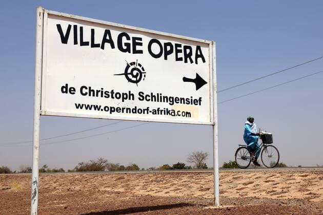 Hinweisschild zum Operndorf des 2010 verstorbenen Film- und Theaterregisseurs Christoph Schlingensief am Rande der Ortschaft Ziniaré, etwa 40 Kiliometer nordoestlich von Quagadougu, der Hauptstadtvon Burkina Faso --- Foto: F.Stark