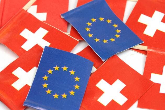Flagge der EU Europäische n Union liegt inmitten Flaggen der Schweiz
