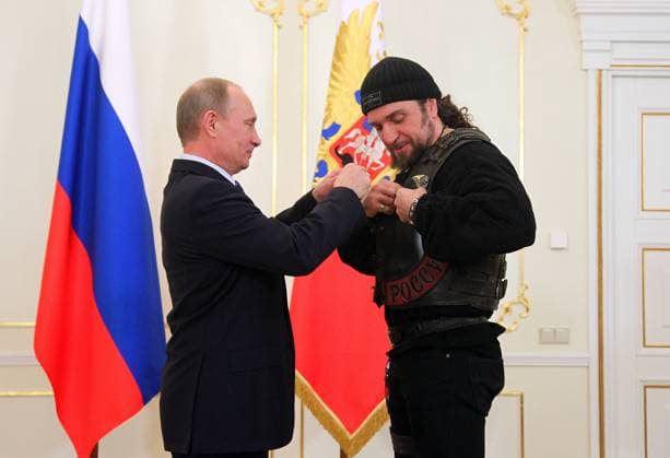 ITAR-TASS: MOSCOW REGION, RUSSIA. MARCH 14, 2013. Russia s president Vladimir Putin (L) awards Alexander Zaldostanov aka Khirurg Surgeo , leader of the Nochnye Volki Night Wolves motorcycle club, with the Order of Honour during his meeting with participants of founding congress of the Russian Military Historical Society, at Novo-Ogaryovo residence.  RE11657C