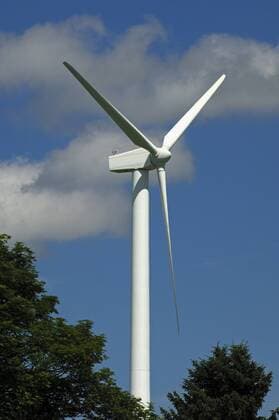 Schlanke Windturbine vor blauem Himmel, Schweiz  1026200745