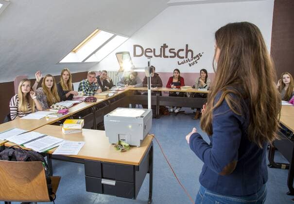 Schule, Gymnasium, Oberstufe, Abiturkurs, 12. Klasse. Deutschunterricht eines Deutsch Leistungskurs. Lehrerin im Unterricht.