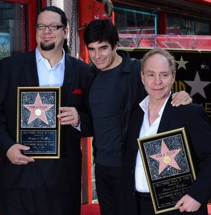 Magician David Copperfield (C) joins Penn Jillette (L) and Raymond Teller (R) of the comedy magic duo Penn & Teller, during an unveiling ceremony, honoring the pair with the 2,494th star on the Hollywood Walk of Fame in Los Angeles on April 5, 2013.  LAP2013040506