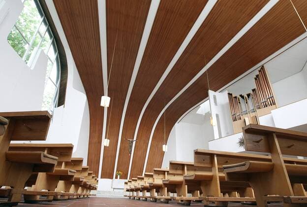 Architektur von Alvar Aalto Innenraum der evangelischen Heilig Geist Kirche in Wolfsburg des Architekten Alvar Aalto (1898-1976) (Foto vom 30.08.2012). Eine dunkle Oregon-Pine-Holzfertäfelung zeichnet sanft den Dachschwung der Kirche nach. Bei einem Vorgespräch mit Gemeindevertretern skizzierte der finnische Architekt erstmals die geschwungene Dachform auf einer Serviette. Das nach einem fächerförmigen Grundriss geplante Gebäude verjüngt sich immer weiter zur Altarempore hin. Die Blicke der Kirchengäste werden so automatisch immer wieder auf das frei hängende Kreuz über dem Altar gezogen. Alvar Aalto gehörte zu den wichtigsten Architekten des vergangenen Jahrhunderts. Zwei Kirchen baute er in Wolfsburg. Heute gelten sie als Schätze aus Ziegelstein und Beton. Lange fristeten die Wolfsburger Aalto-Bauten aber eher ein Schattendasein. Der Name Aalto steht in einer Reihe mit Frank Lloyd Wright, Walter Gropius oder Lud 393478 EDITORIAL USE ONLY