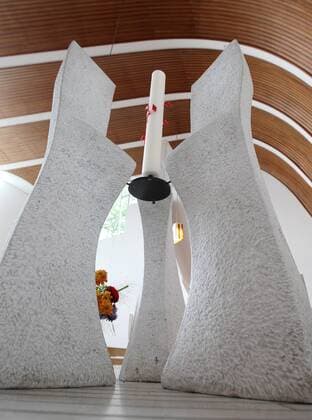 Architektur von Alvar Aalto Ein kunstvoll geschwungener Kerzenhalter auf der Altarempore der evangelischen Heilig Geist Kirche in Wolfsburg des Architekten Alvar Aalto (1898-1976) (Foto vom 30.08.2012). Eine dunkle Oregon-Pine-Holzfertäfelung zeichnet sanft den Dachschwung der Kirche nach. Bei einem Vorgespräch mit Gemeindevertretern skizzierte der finnische Architekt erstmals die geschwungene Dachform auf einer Serviette. Das nach einem fächerförmigen Grundriss geplante Gebäude verjüngt sich immer weiter zur Altarempore hin. Die Blicke der Kirchengäste werden so automatisch immer wieder auf das frei hängende Kreuz über dem Altar gezogen. Alvar Aalto gehörte zu den wichtigsten Architekten des vergangenen Jahrhunderts. Zwei Kirchen baute er in Wolfsburg. Heute gelten sie als Schätze aus Ziegelstein und Beton. Lange fristeten die Wolfsburger Aalto-Bauten aber eher ein Schattendasein. Der Name Aalto steht in einer Re 393479 EDITORIAL USE ONLY