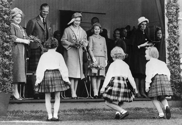 8 SEPTEMBER 1961 THREE YOUNG GIRLS CURTSEY AFTER PRESENTING FLOWERS TO THE ROYAL FAMILY AT THE HIGHLAND GAMES IN BRAEMAR, ABERDEENSHIRE, SCOTLAND. UnitedArchives00124378 