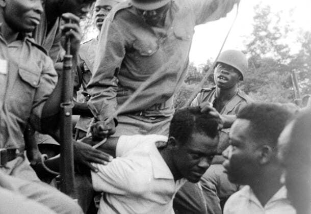 Leopoldville : A group of snarling soldiers of Colonel Mobutu s forces roughly man handle ex Congo Premier Patrice Lumumba ( centre white shirt ) after he was brought here after his arrest here on December 3rd . 5 December 1961 UnitedArchives00413796 