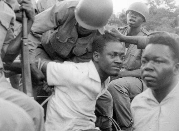 Leopoldville : A group of snarling soldiers of Colonel Mobutu s forces roughly man handle ex Congo Premier Patrice Lumumba ( centre white shirt ) after he was brought here after his arrest here on December 3rd . 5 December 1961 UnitedArchives00413799 