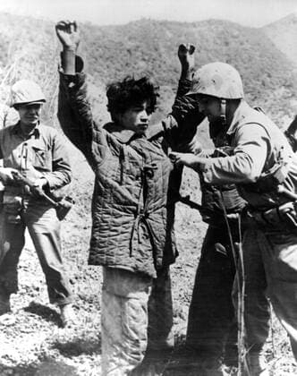 Korea-Krieg 1950-1953 - Aufnahmedaten geschätzt The War in Korea, 19th June 1951 A United States Marine carefully searches a captured Chinese Communist for concealed weapons to prevent him from later turning upon his captors and attacking them with a gun or knife hidden in his clothing. More than 150,000 Chinese and North Korean prisoners have been taken since aggression started in Korea in June 1950. UnitedArchives00467027 