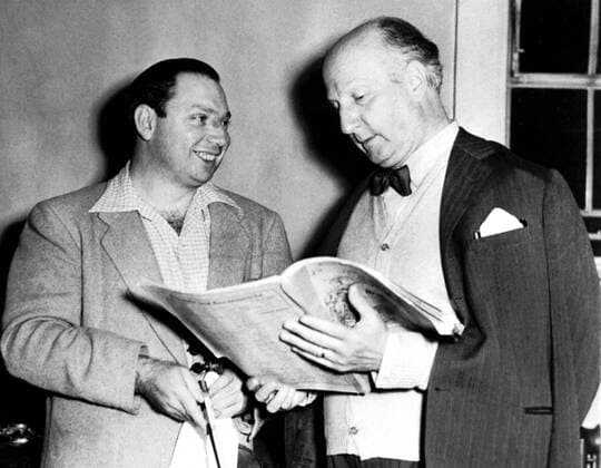 Vittorio Gui rehearsing the Rome Symphony Orchestra at the Usher Hall for an Edinburgh Festival performance. The solo violinist is Isaac Stern, who is going over the score with Gui 31st August 1953 UnitedArchives00504437 