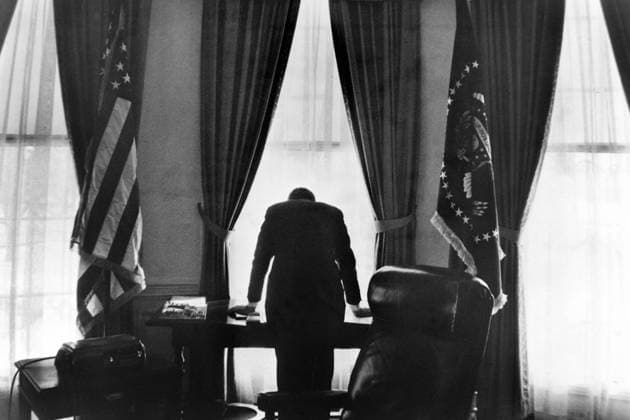 AMERICAN PRESIDENT JOHN F KENNEDY LEANS OVER HIS DESK IN THE WHITE HOUSE, WASHINGTON DC, USA. 1962 UnitedArchives00511257 