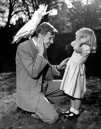 IMAGO ICONS: Sir David Attenborough 3 year old Susan and her father David Attenborough cover their ears as sulphur crested cockatoo Georgie lets out a piercing shriek. 7th December 1957. UnitedArchives00563834 