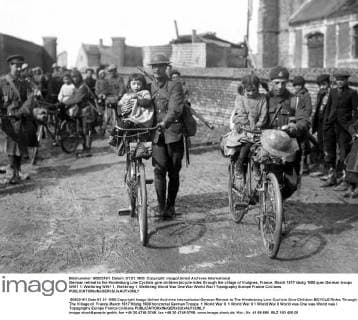 German retreat to the Hindenburg Line Cyclists give children bicycle rides through the village of Vraignes, France. March 1917 UnitedArchives00575094 