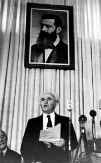 A few hours before the British Mandate for Palestine ended at midnight on 14th May, the Jewish National Council in Tel Aviv proclaimed a new Jewish State of Israel. The National Council is to act as a provisional Government, and Mr Ben Gurion was made Prime Minister. Photo shows Mr Ben Gurion standing in centre proclaiming the new Jewish State of Israel at Tel Aviv. UnitedArchives00575109 