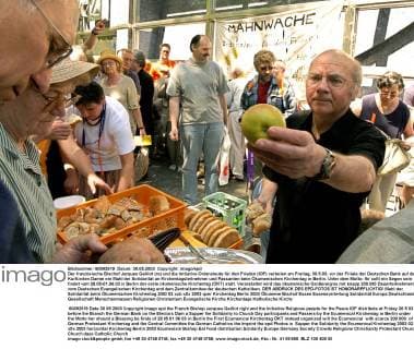 Der französische Bischof Jacques Gaillot (re) und die Initiative Ordensleute für den Frieden (IOF) verteilen am Freitag, 30.5.03, vor der Filiale der Deutschen Bank auf dem Kurfürsten Damm ein Mahl der Solidarität an Kirchentagsteilnehmer und Passanten beim Ökumenischen Kirchentag in Berlin. Unter dem Motto: Ihr sollt ein Segen sein findet vom 28.05-01.06.03 in Berlin der erste ökumenische Kirchentag (ÖKT) statt. Veranstaltet wird das ökumenische Großereignis mit knapp 200.000 Dauerteilnehmern vom Deutschen Evangelischen Kirchentag und dem Zentralkomitee der deutschen Katholiken. DER ABDRUCK DES EPD-FOTOS IST HONORARPFLICHTIG! Mahl der Solidarität beim Ökumenischen Kirchentag 2003 82439 EDITORIAL USE ONLY