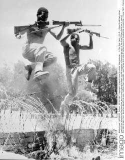 6 Day War Cairo, U.A.R.: United Arab Republican youths from schools and universities, are currently going through a crash program of training as part of the Arab Military build-up in view of the UAR-Israeli crisis. Here two Egyptians leap, holding their bayonets, over flames and rolls of barbed wire in a toughening up exercise. 2 June 1967 , Kairo UnitedArchives00928653 