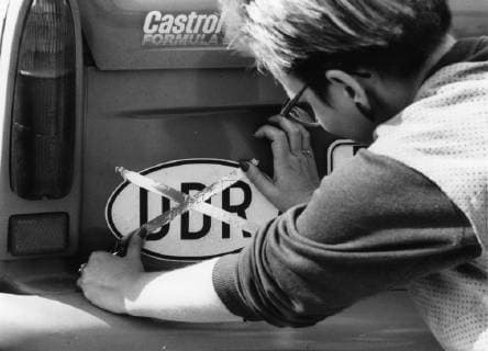 Über Ungarn ausgereiste DDR-Flüchtlinge im Notaufnahmelager Vilshofen am 11.09.1989. Eine Frau kreuzt das DDR-Autokennzeichen aus. DER ABDRUCK DES EPD-FOTOS IST HONORARPFLICHTIG! Eine Frau, DDR-Flüchtling, kreuzt das DDR-Autokennzeichen aus, 11.09.1989 308141 EDITORIAL USE ONLY