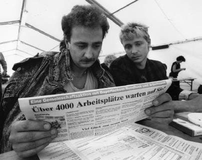 Über Ungarn ausgereiste DDR-Flüchtlinge am 11.09.1989 im Notaufnahmelager Vilshofen. Zwei Männer lesen eine Lokalzeitung mit Meldung über mögliche Arbeitsplätze für die DDR-Bürger in Bayern. DER ABDRUCK DES EPD-FOTOS IST HONORARPFLICHTIG! DDR-Flüchtlinge am 11.09.1989 im Notaufnahmelager Vilshofen 308142 EDITORIAL USE ONLY