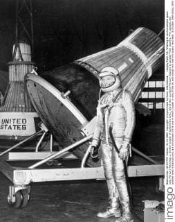 Langley Field, VA: Wearing an aluminiumized space suit, Mercury Astronaut L. Gordon Cooper of Carbondale Colo., stand near a project Mercury Capsule at Langley Field recently, The capsule, and another seen in background, are prototypes of the one in which Cooper or one of the six astronauts will ride into space next year. 3 October 1960 UnitedArchives00938058 