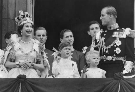 Queen Elizabeth II gestures as her husband Duke of Edinburgh Prince Phillip and children Prince Charles and Princess Anne watch the Royal Air Force flypast salute from the balcony of Buckingham Palace 2 Junne 1953 , Krönung, Krönungsfeierlichkeiten, Königin, Festivität, Feiertag, Krönungsfeierlichkeit, 1950er, 50er Jahre, Prinz  UnitedArchives01028314