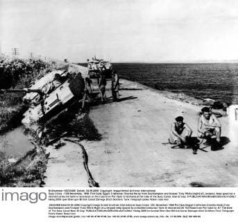 Suez Crisis - 12th November, 1956: Port Said, Egypt: Craftsman Charles Hardy from Southampton and trooper Tony White (right) of Liverpool, keep guard as a ditched centurion tank is recovered on the road from Port Said to Ishmalia at the side of the Suez Canal, near El Cap. Â  UnitedArchives01029777