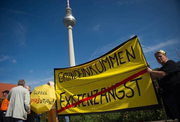 Berlin, Teilnehmer der Demonstration Grundeinkommen ist ein Menschenrecht für ein Bedingungsloses Grundeinkommen am Samstag (14.09.13) vor dem Fernsehturm mit einem Transparent mit dem Aufdruck Grundeinkommen und dem durchgestrichenen Schriftzug Existenzangst .