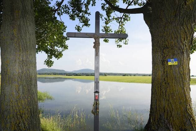 durch Hochwasser der March überschwemmtes Feld und Wegkreuz im Marchfeld in Engelhartstetten, Österreich, Niederösterreich, Donau