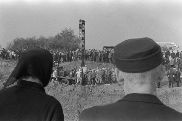 Vor 50 Jahren, am 24. Oktober 1963, wurden in einem Stollen der Eisenerzgrube Lengede-Broistedt bei Peine 129 Bergleute in 60 m Tiefe verschüttet. Die Rettung von 11 eingeschlossenen Bergleuten nach 14 Tagen ging als Wunder von Lengede in die Geschichte ein, Im Vordergrund zwei Zuschauer, Senioren, die die Rettungsarbeiten beobachten, zu sehen ist in der Mitte der Bohrturm, um den herum Arbeiter stehen und arbeiten, um Kontakt zu verschollenen, eingeschlossenen Bergleuten herzustellen; Grubenunglück und Wunder von Lengede im Oktober November 1963, SW-Aufnahme, 25.10.1963. Grubenunglück von Lengede, Alter Mann, Schacht Mathilde, Wunder von Lengede, Bergmann, Kumpel, Bergleute, Wassereinbruch, Grube, Erzbergwerk, Bergwerk, Unter Tage, Rettung, Dahlbuschbombe, Rettungsbohrung, Eisenerzgrube Lengede-Broistedt, Katastrophe, Bohrloch, Verschüttete, Rettungskapsel, Steiger, Klärteich,