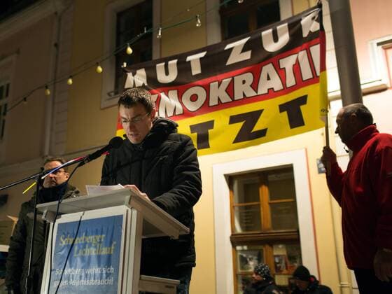 Stefan Harung, NPD-Funktionär und Organisator des Fackelmarsch gegen Asylbewerber in Schneeberg hält eine Rede: Begleitet von mehreren Gegendemonstrationen findet in Schneeberg der dritte Facklemarsch von Neonazis und Bürgern (Lichtellauf) gegen die Unterbringung von Flüchtlingen in der ehemaligen Jägerkaserne mit ca. 1500 Teilnehmern statt. Der Aufmarsch ist von dem lokalen NPD-Funktionär Stefan Hartung angemeldet, neben organisierten Neonazis nehmen auch zahlreiche Bürger Schneebergs an dem Fackelmarsch teil. Am Rande des Aufmarsches werden mehrfach Journalisten von Auzugsteilnehmern bedroht, ein Pressefotograf wird zusammengeschlagen und muss im Krankenhaus behandelt werden. Gegen den Aufmarsch protestieren mehrere hundert Bürger auf einer Kundgebung der demokratischen Parteien Schneebergs, an einer überregionalen Demonstration von Antifagruppen beteiligten sich ca. 1500 Menschen. Sch