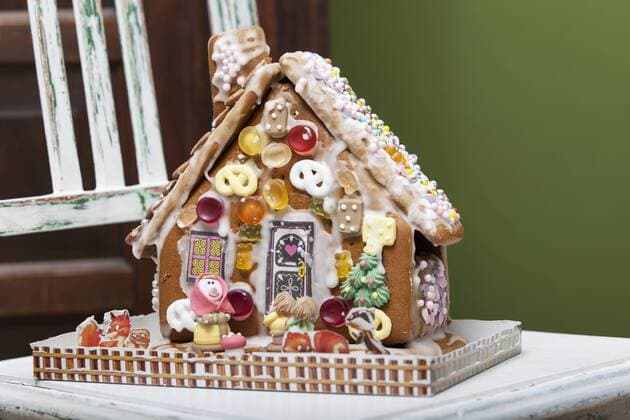 In der Weihnachtszeit ein gebasteltes Lebkuchenhaus im Advent. Süßigkeiten, Lebkuchen, Haus, Süßwaren, Gummibärchen, Zucker, Dekoration, Weihnachten, Advent, Adventszeit, Weihnachtszeit, basteln mit Kindern, Hexenhaus, Hexenhäuschen, backen, gebacken.