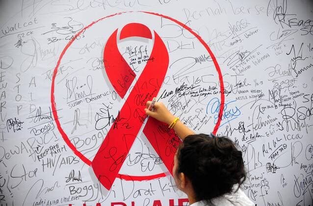 An Indonesian woman signs on a board during an HIV AIDS awareness campaign on the World AIDS Day in Jakarta, Indonesia, Dec. 1, 2013. A commemoration for World AIDS Day kicked off on Dec. 1. (Xinhua Zulkarnain) INDONESIA-JAKARTA-WORLD AIDS DAY 