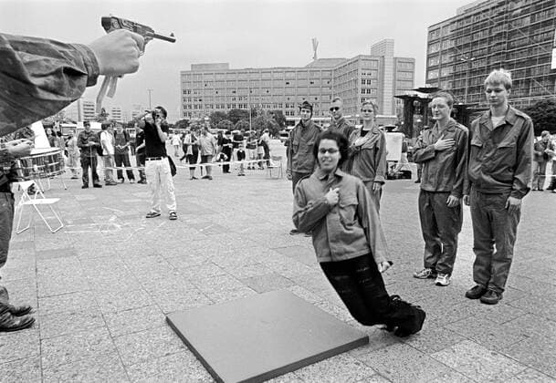 Heldentod sterben eine Gruppe von Gegnern des Bundeswehrgelöbnisses nimmt verkleidet mit Bundeswehr - und NVA Uniformen militärische Rituale aufs Korn, Station: Heldentod sterben, Alexanderplatz, Protest gegen die jährlichen Gelöbnisse der Bundeswehr im Bendlerblock, abgeschirmt von der Öffentlichkeit, DEU, Berlin-Mitte, 17.07.2002;