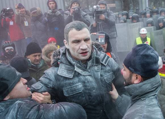 ITAR-TASS: KIEV, UKRAINE. JANUARY 19, 2014. Udar party leader Vitali Klitschko (C) sprayed with powder from a fire extinguisher near Dynamo Stadium during clashes between opposition and police. Protesters rally against new laws passed by Ukrainian parliament.  00000001 RE136553