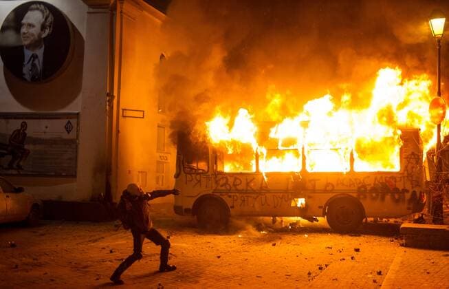 ITAR-TASS: KIEV, UKRAINE. JANUARY 19, 2014. A burning bus seen near Dynamo Stadium during clashes between demonstrators and police. Protesters rally against new laws passed by Ukrainian parliament.  RE136557
