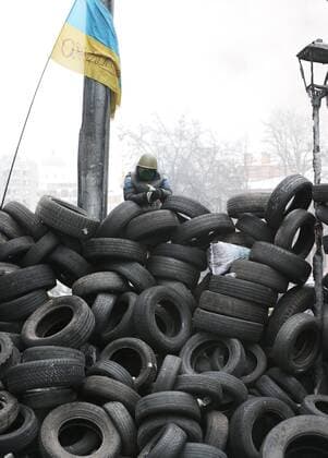 ITAR-TASS: KIEV, UKRAINE. JANUARY 28, 2014. A protester on a barricade built of tyres during anti-government unrest in Kiev.  Aufmacher RE1372AF