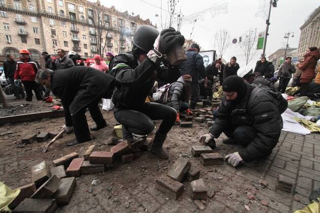 Anti-government protesters gather stones at a barricade during clashes with Ukrainian riot police in Kiev on February 19, 2014. At least 25 people have been killed in the worst violence since Ukraine gained its independence in 1991.  KIE2014021906
