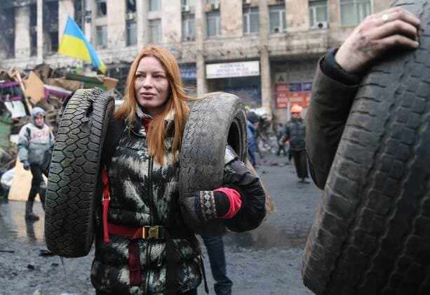 ITAR-TASS: KIEV, UKRAINE. FEBRUARY 20, 2014. Opposition protesters carry old tyres to be burnt during violent clashes between anti-government demonstrators and Ukrainian police, interior troops men in central Kyiv.  Aufmacher 1792