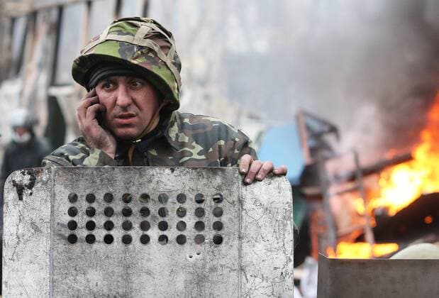 ITAR-TASS: KIEV, UKRAINE. FEBRUARY 20, 2014. An opposition protester wearing a helmet seen in central Kyiv during violent clashes between anti-government demonstrators and Ukrainian police, interior troops men. The slogan reads: Freedom or death .  kurios Aufmacher premiumd RE13A533