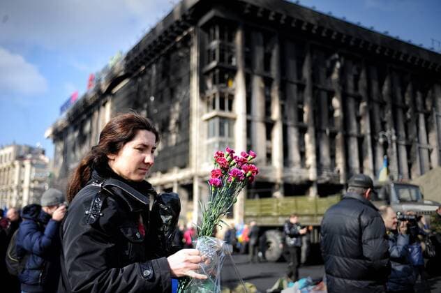 (140226) -- KIEV, Feb. 24, 2014 (Xinhua) -- A woman prepares to lay a bouquet to mourn victims of clashes on the Maidan Independence Square in Kiev, capital of Ukraine, on Feb. 24, 2014. (Xinhua Dai Tianfang) UKRAINE-KIEV-INDEPENDENCE SQUARE-AFTERMATH 