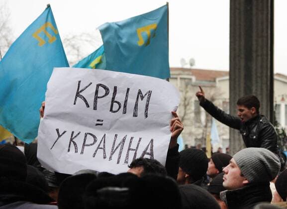 ITAR-TASS: SIMFEROPOL, UKRAINE. FEBRUARY 26, 2014. Demonstrators hold a slogan saying: Crimea = Ukraine rally in support of the new authorities of Ukraine outside the Supreme Council of the Autonomous Republic of Crimea.  RE13B102
