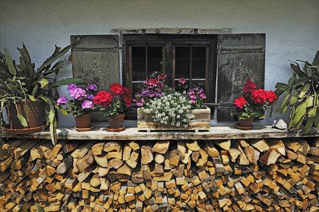 Fenster mit Holzstapel und Blumen im Markus Wasmeier Bauernhof- und Wintersportmuseum, Neuhaus, Schliersee, Oberbayern, Bayern, Deutschland, Europa iblabc03849518.jpg